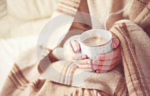 Cup of hot coffee warming in the hands of a girl