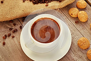 Cup of hot coffee on wooden surface