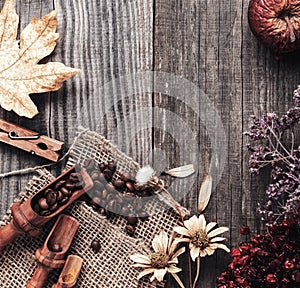Cup of hot espresso among autumn plants on wooden vintage table, coffee on the old board grunge including dried plants