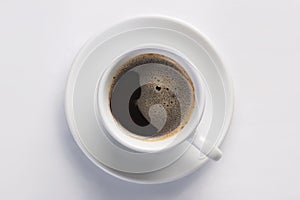 Cup of hot fresh black coffee with foam against white background viewed from top