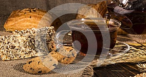 A cup of hot herbal tea and cookies on the old wooden background