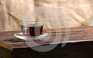 A cup of hot herbal tea and cookies on the old wooden background