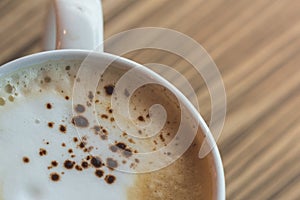 A cup of hot latte, coffee art on the wooden table in relex time