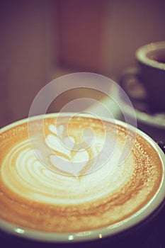 A cup of hot latte coffee, heart shape latte art, coffee lover concept, vintage tone
