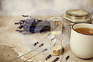 Cup of hot lavender tea. Herbal tea hot drink with sand glass timer..