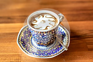 A cup of hot milk  in an antique Thai traditional benjarong style containers