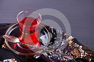 Cup of hot red karkade tea on the black table