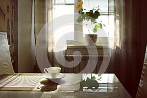 cup of hot steaming coffee on a sunny morning on the kitchen table