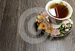 A Cup of hot tea with dried fruits on a table