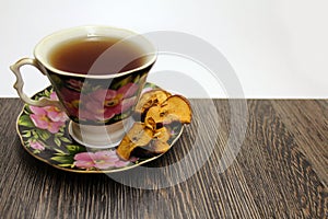 A Cup of hot tea with dried fruits on a table