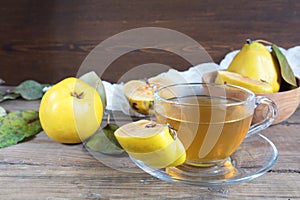 Cup of hot tea and fresh quince fruit on table photo