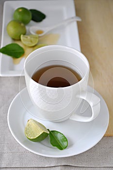 A Cup of Hot Tea with Honey and Lime on Background