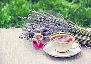 Cup of hot tea and lavender essential oil. Natural medicine for colds. Tea with lavender and remedy. A healing potion.