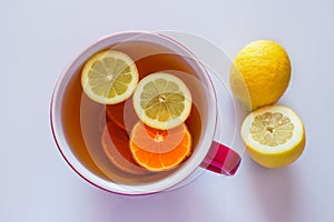 Cup of hot tea with lemon for making a warming drink for flu, coronavirus  and colds.