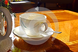 A cup of hot tea with milk on mug, put on wooden table and bright light  from sun in afternonn, Traditional english tea.