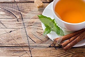 Cup of hot tea with mint and brown sugar on a wooden table Copy sapce