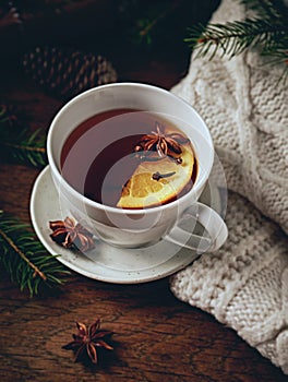 Cup of hot tea with orange and spices for winter and Christmas time