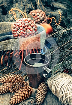 Cup of hot tea on a rustic wooden table. Still life of cones, twine, fir branches. Preparing for Christmas.