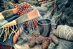 Cup of hot tea on a rustic wooden table. Still life of cones, twine, packthread, fir branches. Christmas.