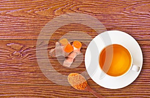 Cup of hot Turmeric tea isolated on wood table