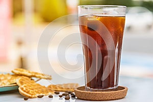 A cup of Iced Americano Coffee with ice cubes placed on a marble table in a coffee shop. Top view of a glass of coffee