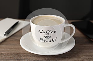 Cup with inscription Coffee Break on wooden table in office