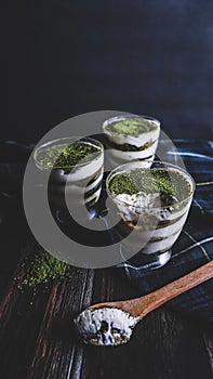 Japanese Green Tea Tiramisu in Cup with plaid cloth and dark cool background