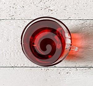 Cup of Karkadeh Red Tea on wooden table