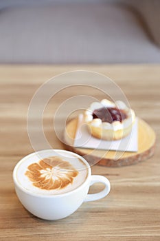 Cup of latte coffee with latte art and strawberry tart pie on wo