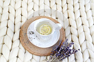 Cup with lavender tea, citrus and honey, croissant, white pastel giant knit blanket