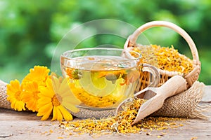 Cup of marigold tea and calendula flowers. photo