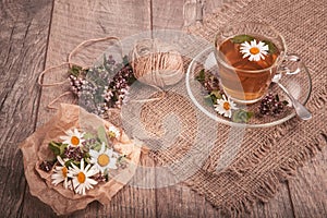 Cup of medicinal chamomile tea on a wooden