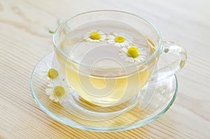 Cup of medicinal chamomile tea on wooden table