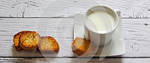 Cup of milk and bread crumbs on a wooden background. Healthy breakfast.