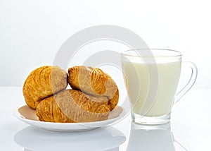 cup of milk with croissant isolated on white background