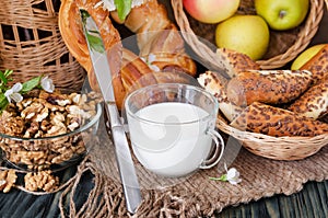 A cup of milk with fresh pastries and nuts