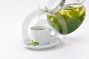 Cup with mint tea and teapot