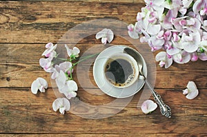 Cup of morning coffee, bouquet of sweet peas