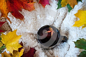 Cup or mug of hot red fruit tea with smoke in cosy room.