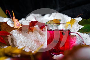 Cup or mug of hot red fruit tea with smoke in cosy room.