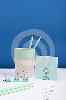 Cup With Pencils And Paperclips Placed On Desk With Clipped Memo With Important Message. Crutial Informations Presented