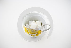 A cup with pieces of sugar Unhealthy food Harm