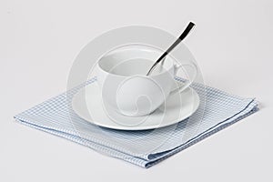 Cup, Plate And Spoon On Folded Gingham Cotton