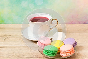 Cup of red tea and colored cakes