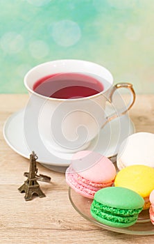 Cup of red tea and colored cakes