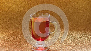 Cup of red tea golden background