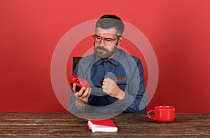 Cup, retro clock and red book on vintage desk