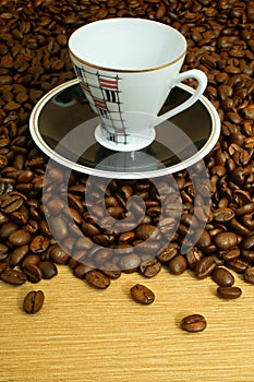 Cup with saucer on coffee beans background