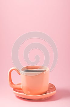 cup with a saucer on a pink background/cup of coffee on a pink background, close up