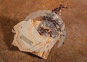 A cup sewn in jute full of coffee beans.